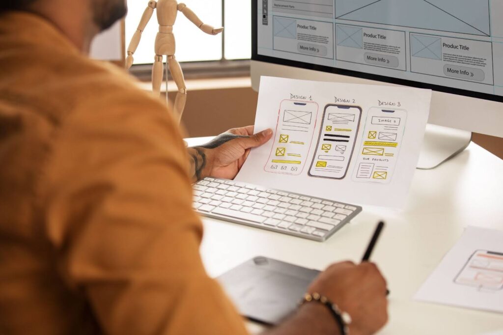 A man develops a custom Shopify app, focused on design, while working on a computer with the app displayed on the screen.